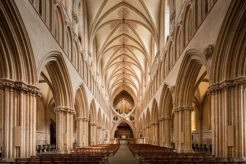 The nave of Wells Cathedral, with its pale stone arches and the great scissor arch at the crossing