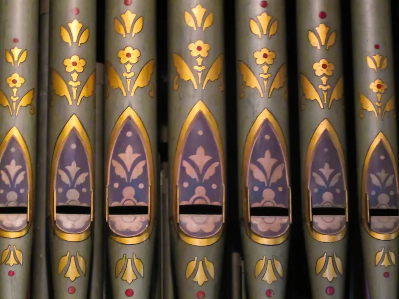 Painted organ pipes decorated with gold flowers on a grey-blue ground